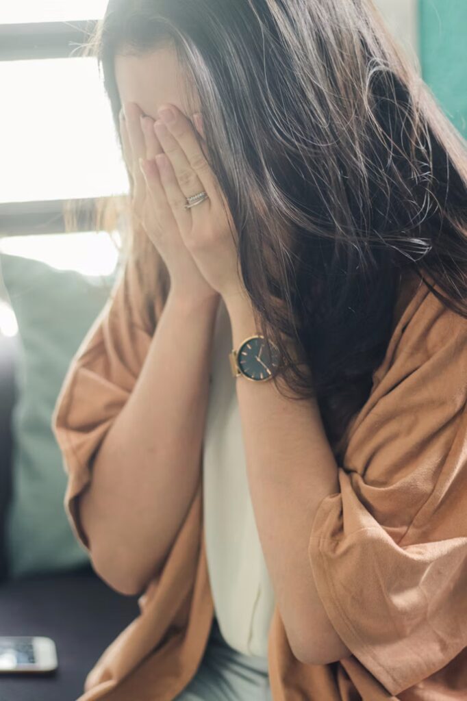 Femme ressentant les tensions physiques de l'anxiété dans la gorge, le plexus solaire et le ventre