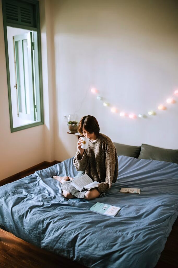 Femme lisant un livre papier au lit, alternative saine aux écrans pour favoriser le sommeil